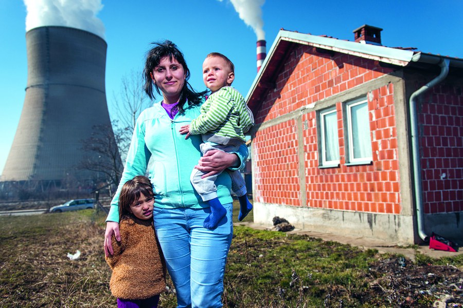 Obiliq, Kosovo, Februar 2015: Meheteme Brahimi (25) findet nach ihrer Flucht mit ihren Kindern Ermonda (4) und Ermond (2) ein neues Heim vis-à-vis des Braunkohlekraftwerks. In diesen Wochen emigrierten rund zehn Prozent der Bevölkerung von Kosovo nach Westeuropa. Foto: Joseph Khakshouri